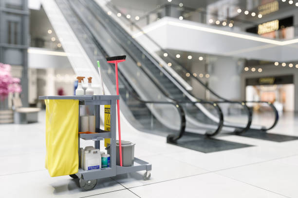 A cleaning cart with yellow and black supplies in a mall, representing Industrial Cleaning Services.