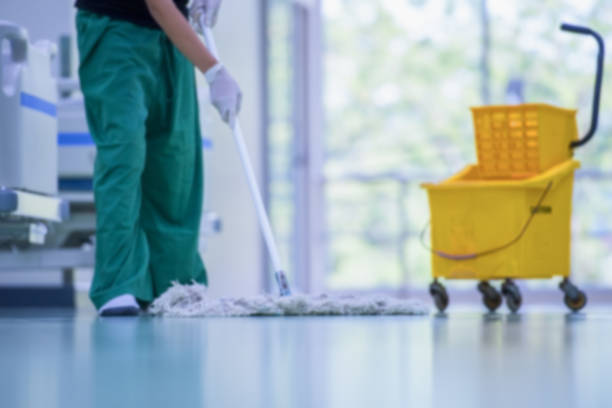  An individual in white gloves sanitizes a hospital bed, highlighting the importance of cleanliness in medical office cleaning.