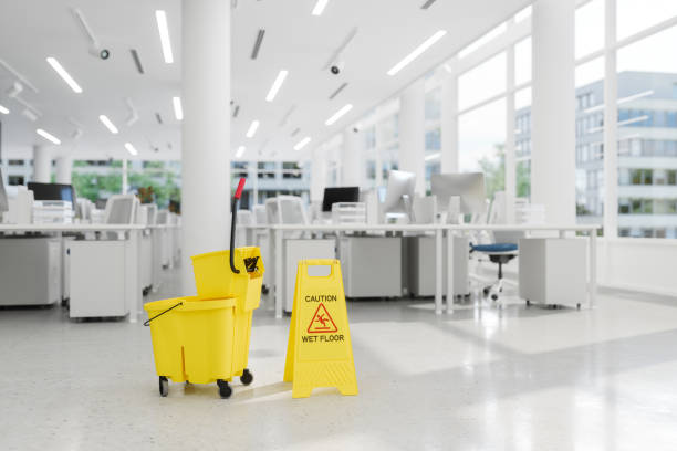 A cleaning cart in yellow and green, marked "Shoddy Janitorial Cleaning," is stationed outside a retail store.