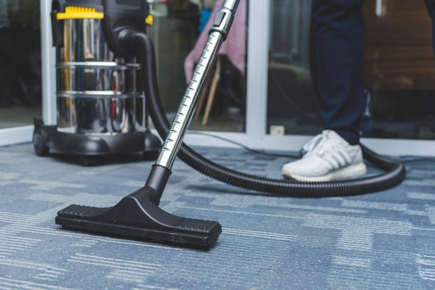 A man cleans a glass door with a vacuum, representing the efficiency of commercial cleaning services.