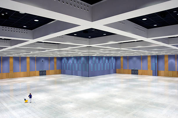 A large empty room featuring blue walls and a white floor, showcasing a clean and spacious environment.